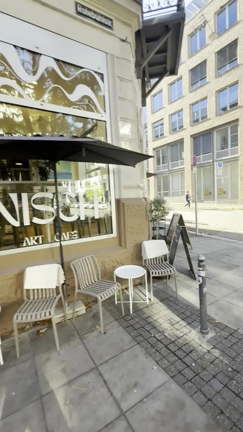 Fassade des Nisch mit Sonnenschirmen und dem Schriftzug im Fenster