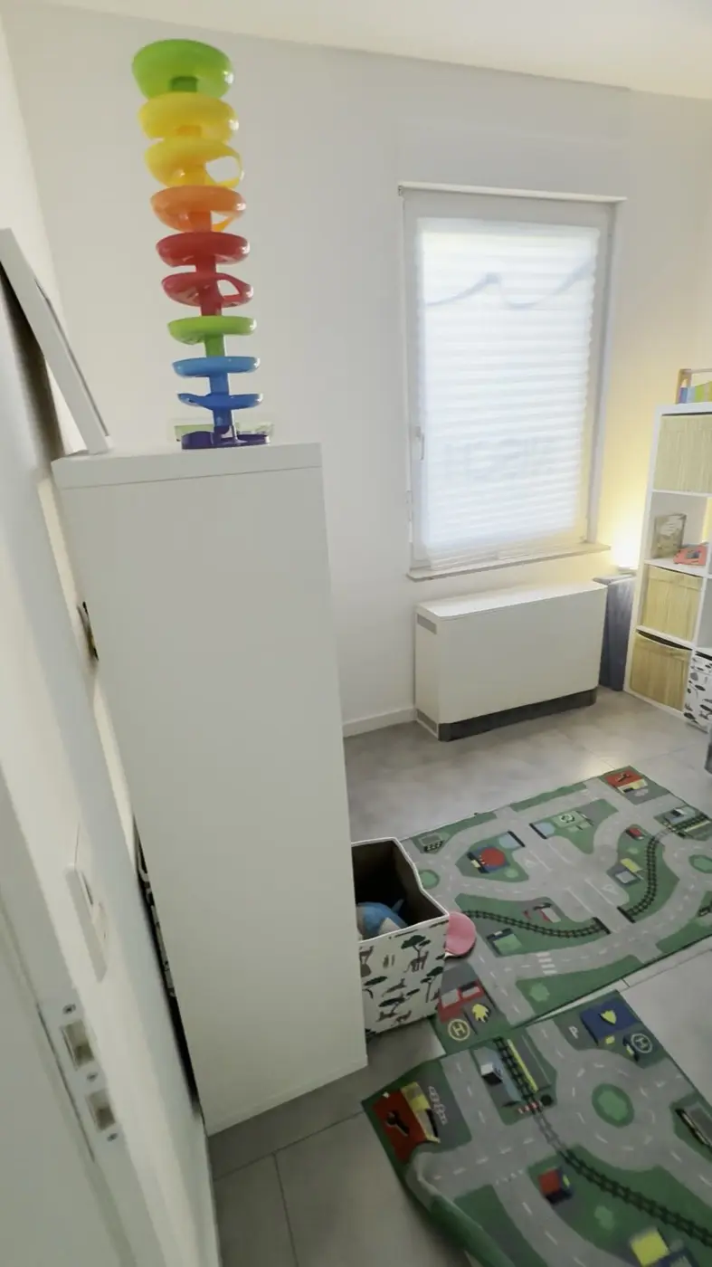 Kinderzimmer mit Spielteppich und Regalen